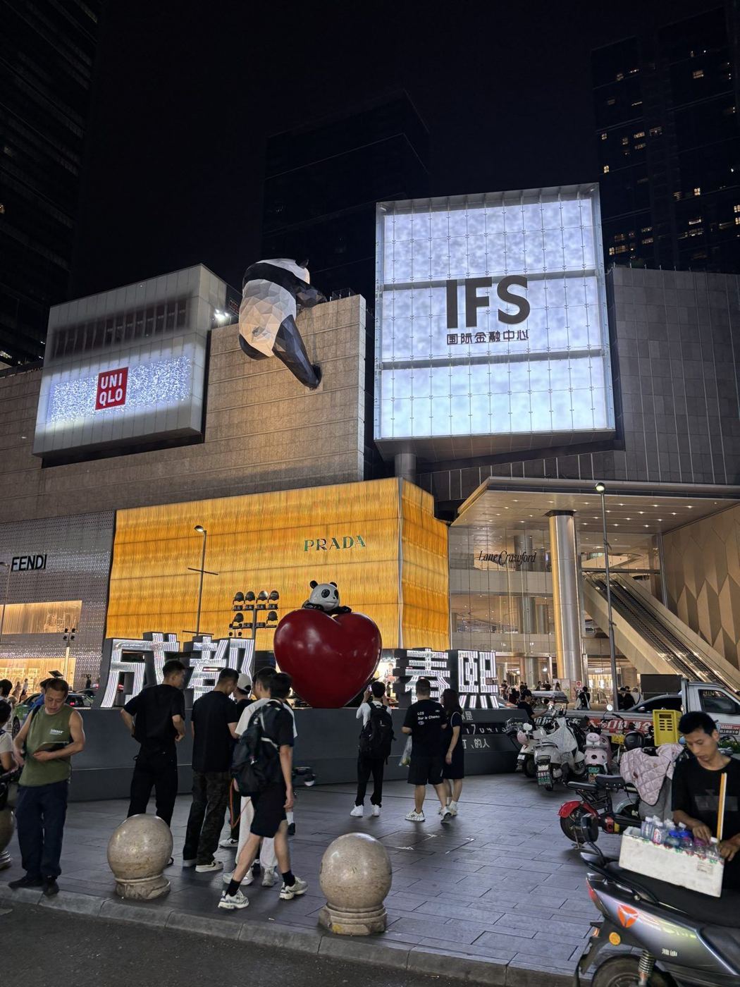 The IFS mall in Chengdu at night: a giant panda climbs the building above a crowd of passers-by