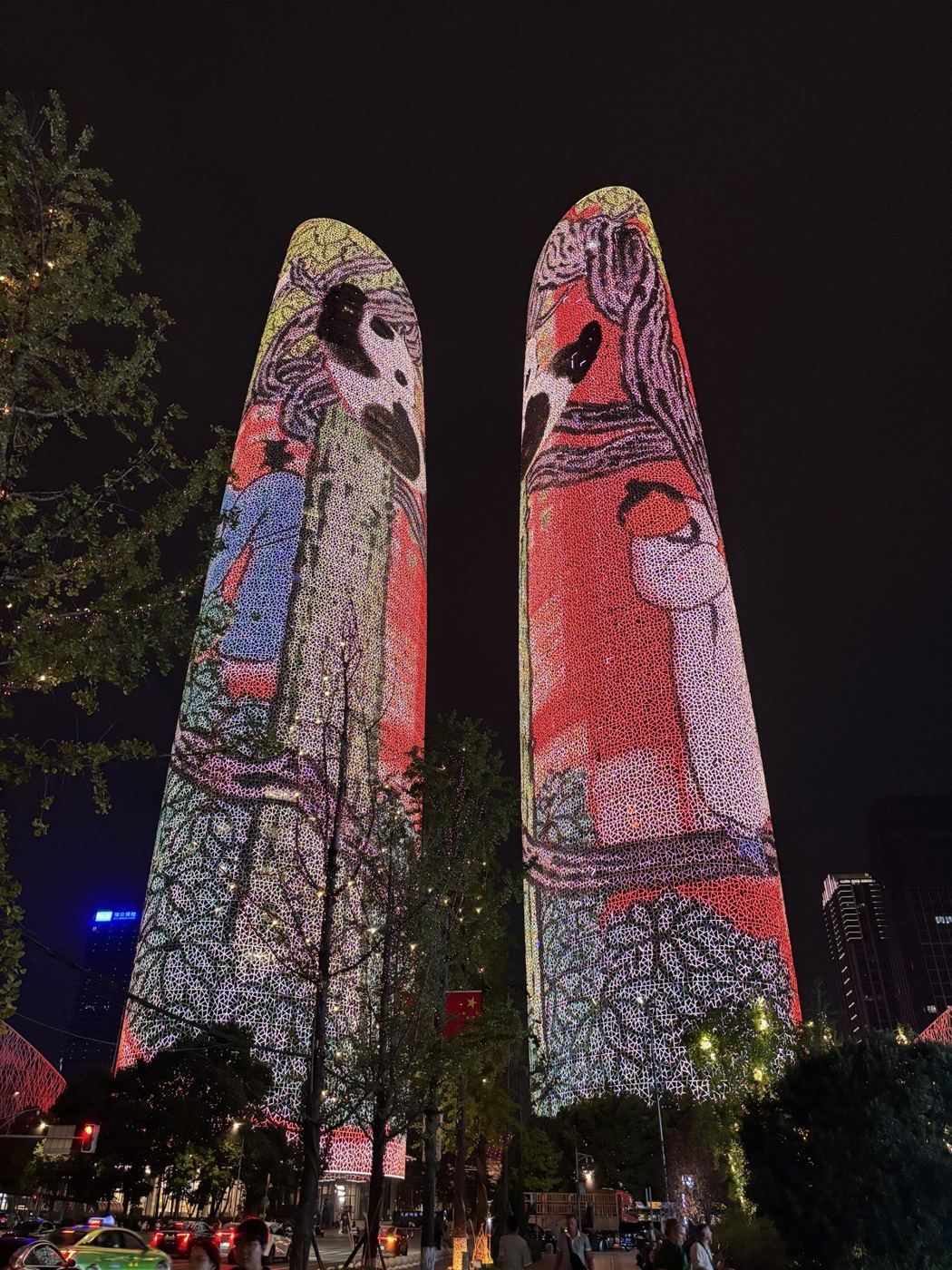 The two Tianfu Towers at night: their entire facades are LED screens showing colourful drawings