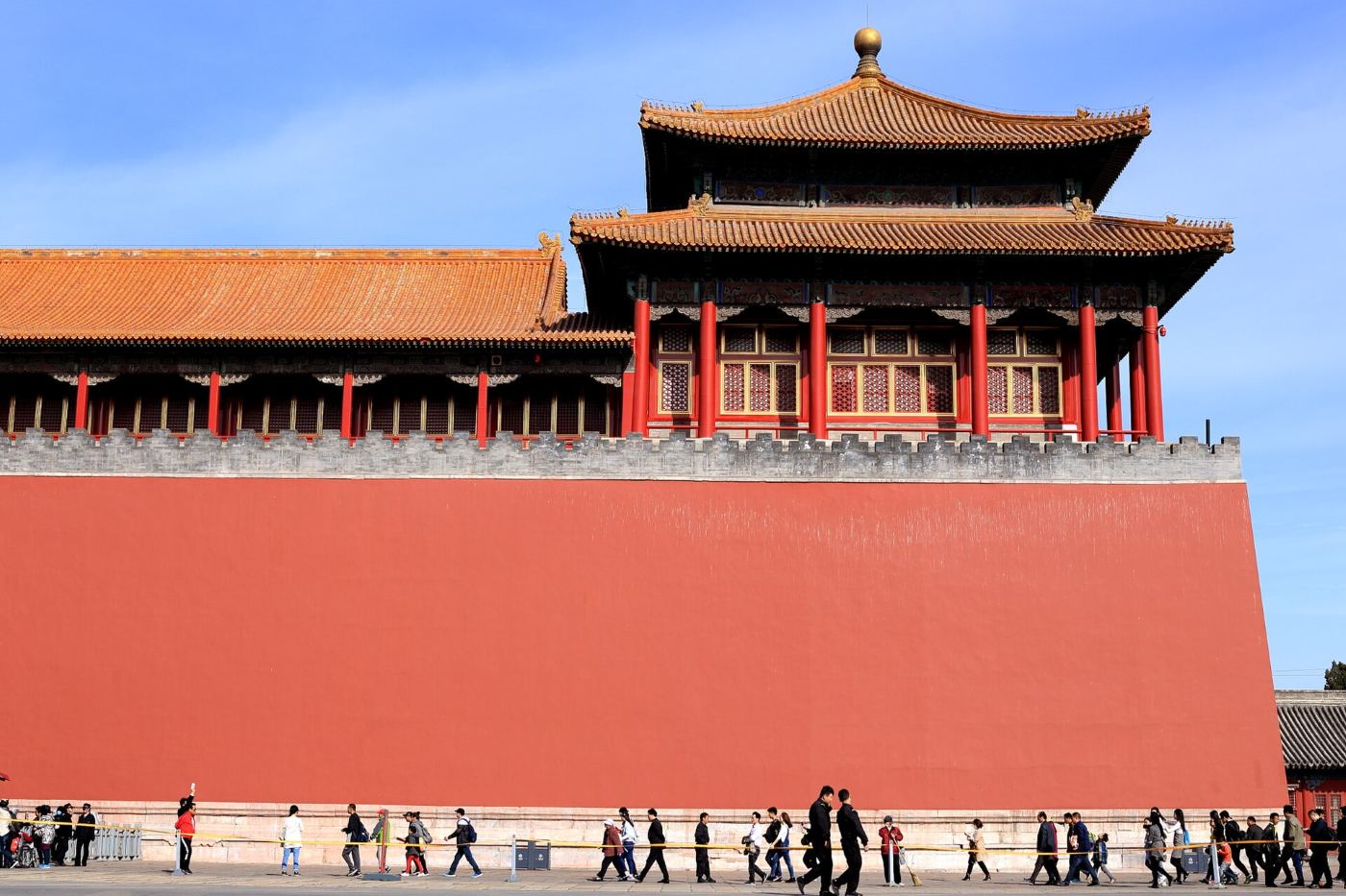 The Meridian Gate (Wumen), the entrance to the Forbidden City in Beijing: a red wall, a pavilion with a yellow roof and visitors walking to the entrance