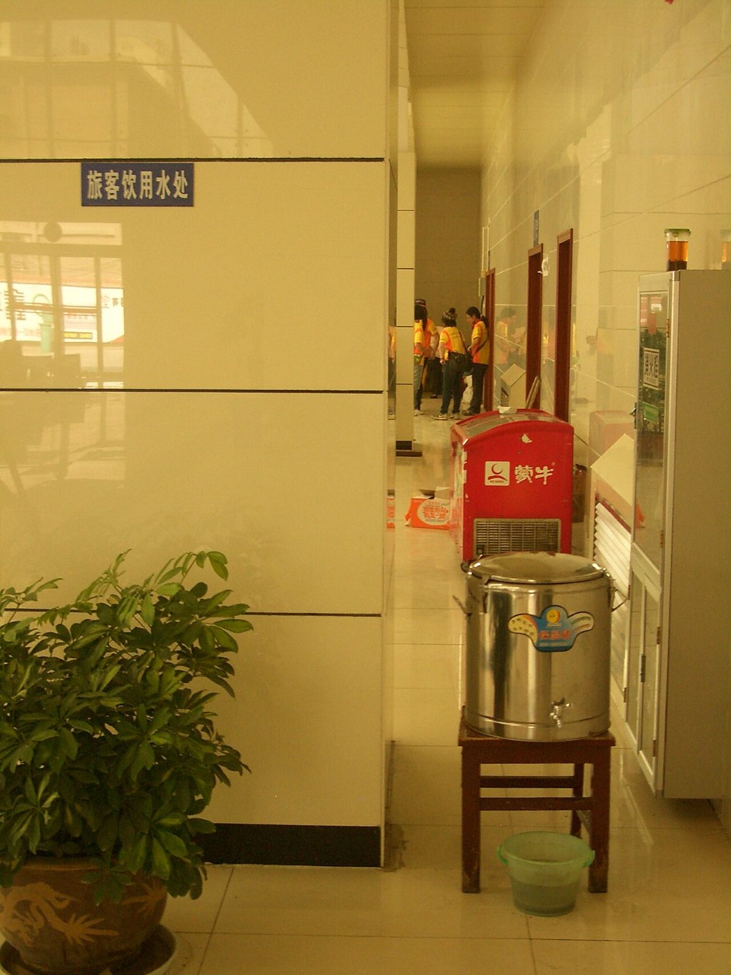 A metal boiler with drinking water in the corner of a bus station hall