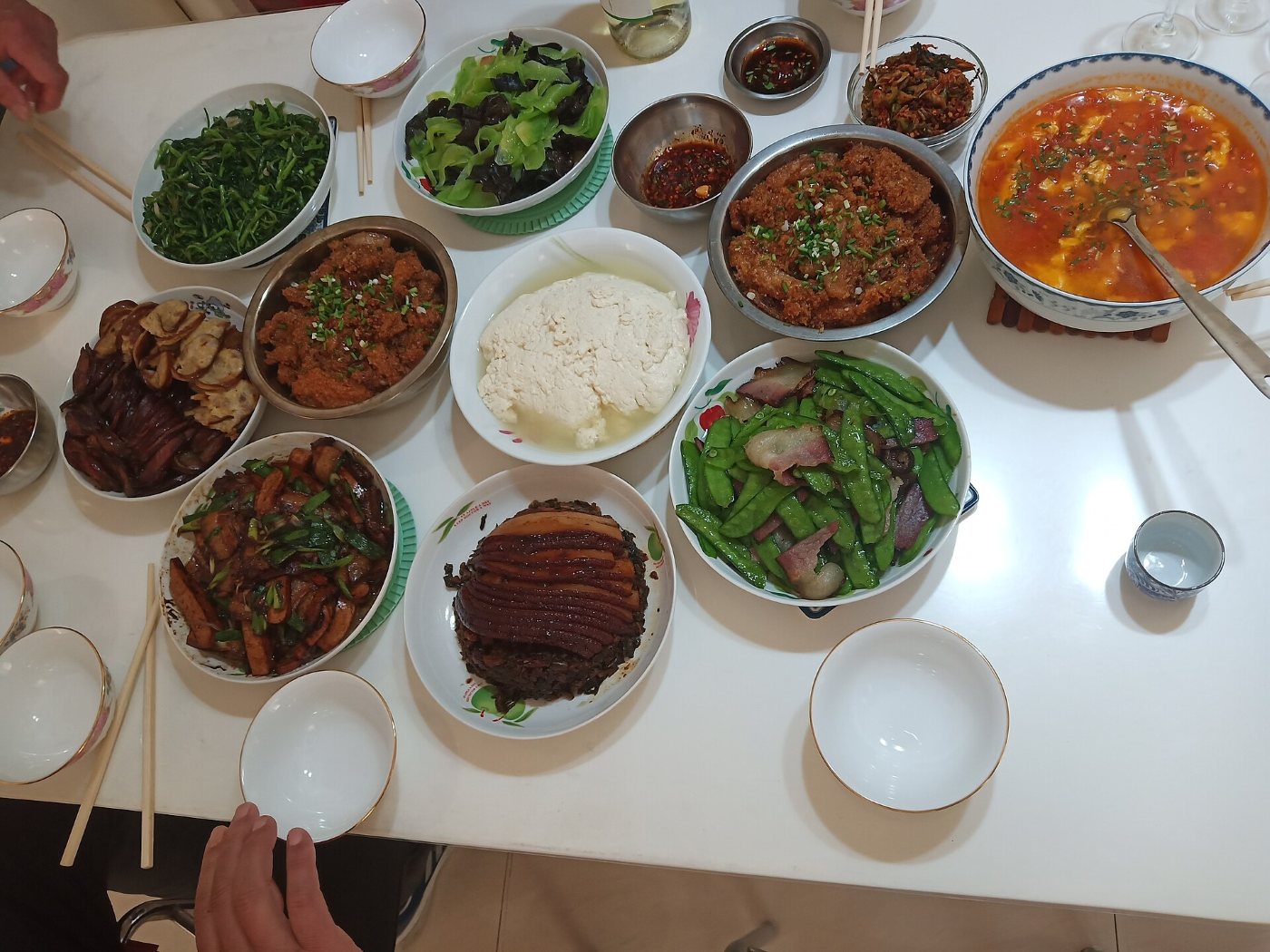 A home dinner in Chongqing: shared dishes in the middle of the table, surrounded by small bowls and chopsticks