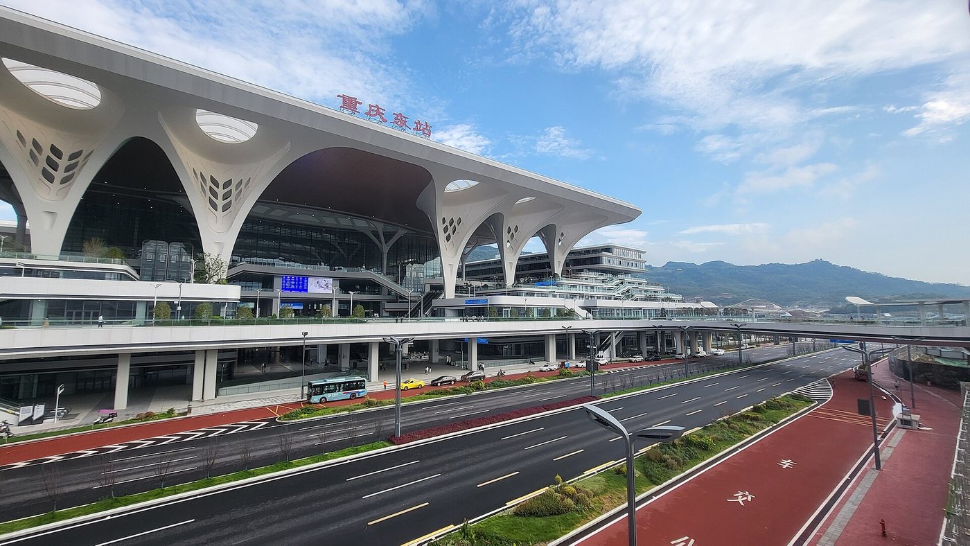 Chongqing East railway station with the sign 重庆东站 and a roof held up by white tree-shaped columns