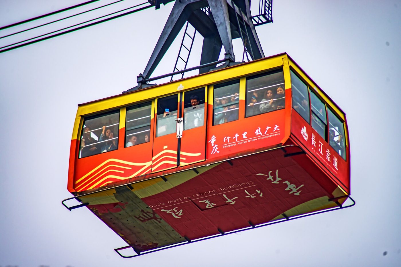 A red Yangtze River Cableway car seen from below against the sky