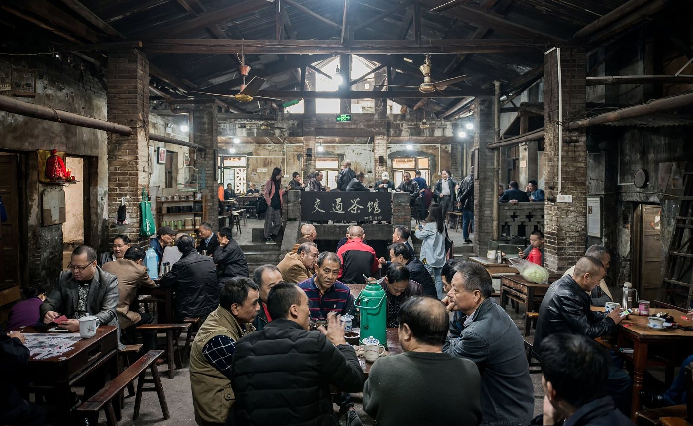 Inside the old Jiaotong teahouse in Chongqing: locals drinking tea and playing cards at wooden tables under a beamed roof