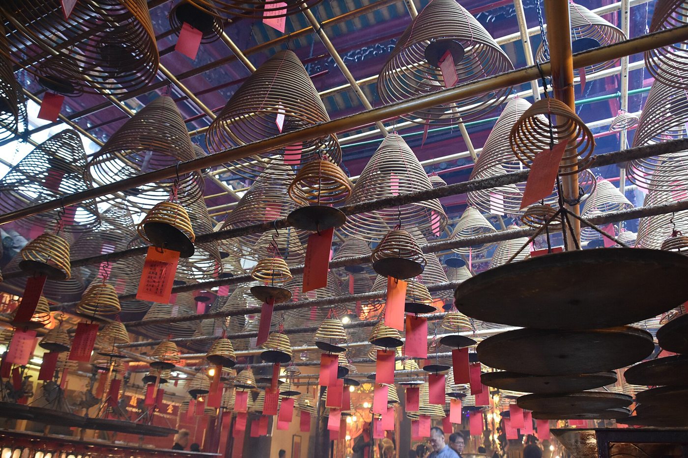 Inside Man Mo Temple: dozens of spiral incense coils hanging from the ceiling with red wish cards