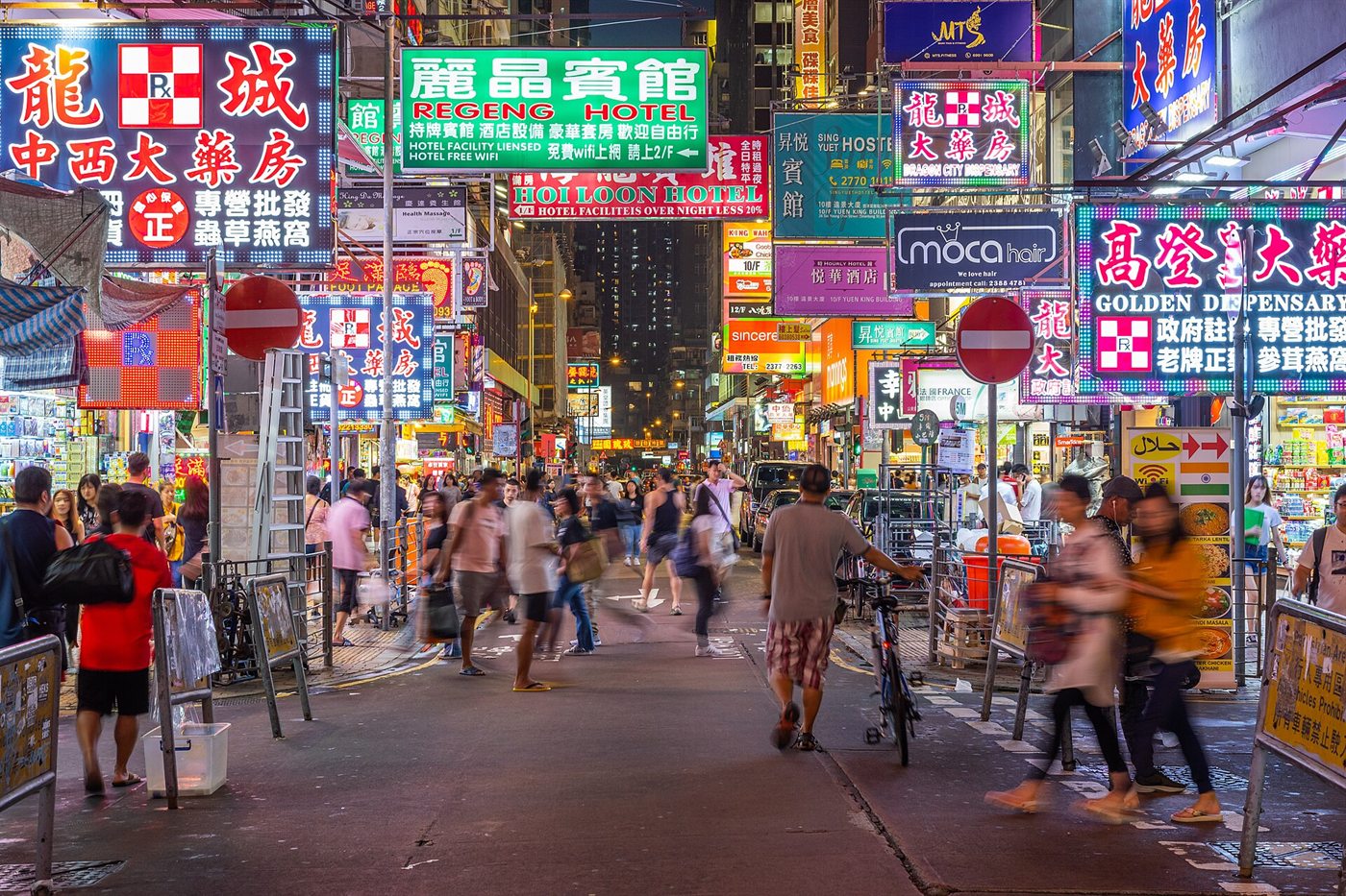 A Mong Kok street at night: dozens of colourful neon signs with Chinese characters above a crowd