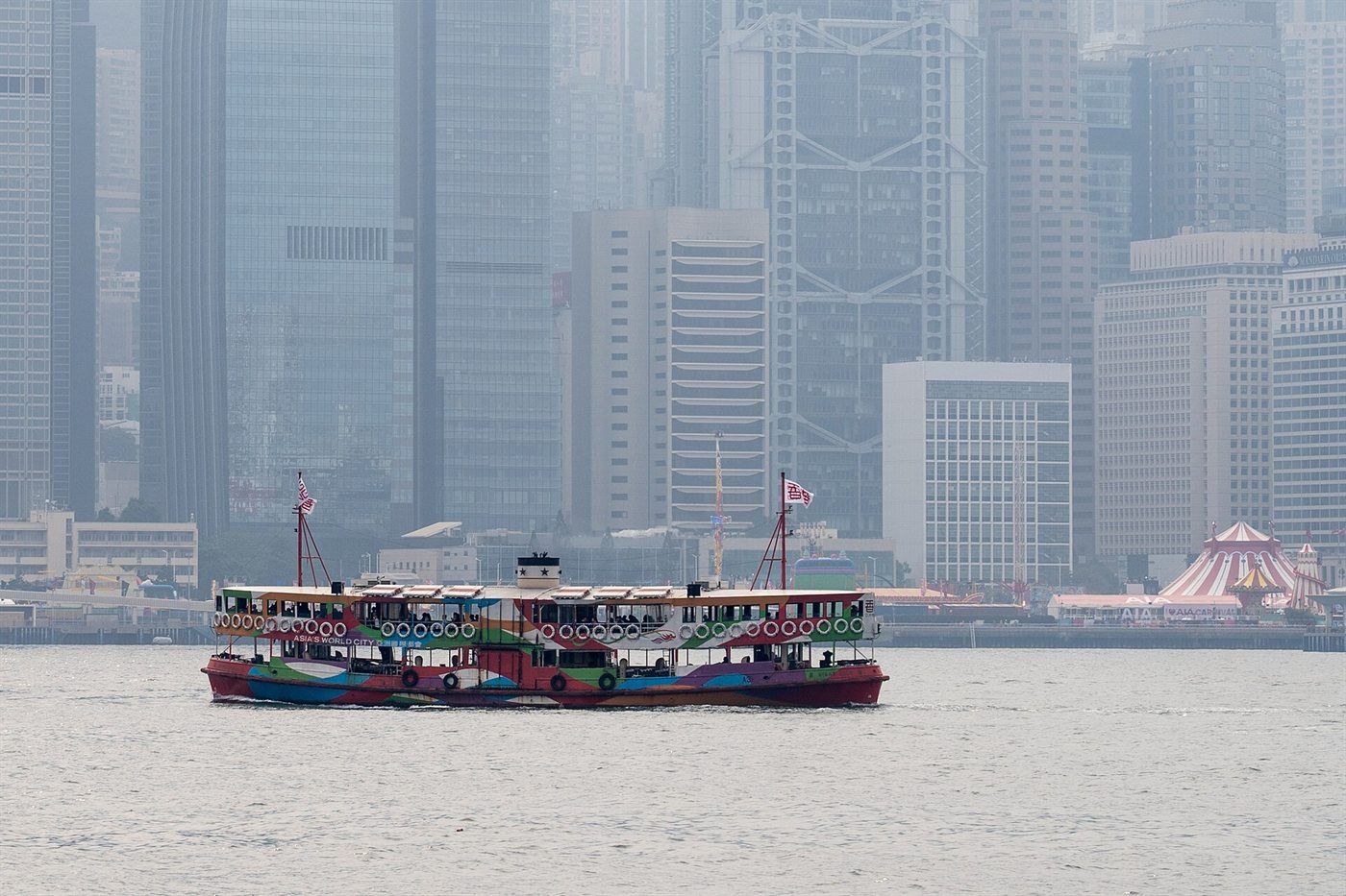 A green-and-white Star Ferry crossing Victoria Harbour, with the towers of Central behind it