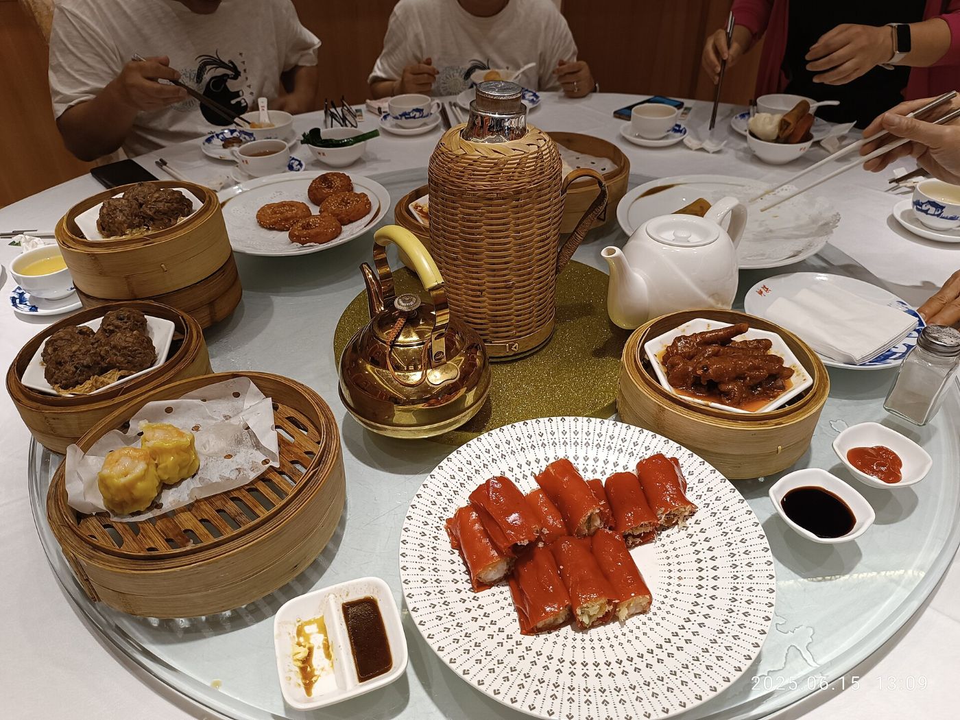 Okrągły stół w restauracji Panxi w Kantonie: bambusowe koszyczki z siu mai i klopsikami wołowymi, naleśniki ryżowe, łapki kurze, czajniczek i termos z herbatą