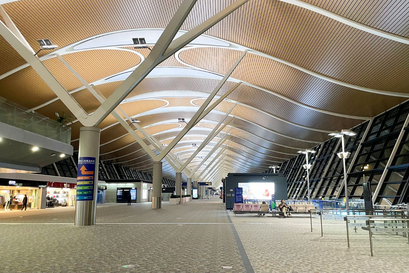 The spacious hall of Terminal 2 at Shanghai Pudong airport with a wavy wooden ceiling