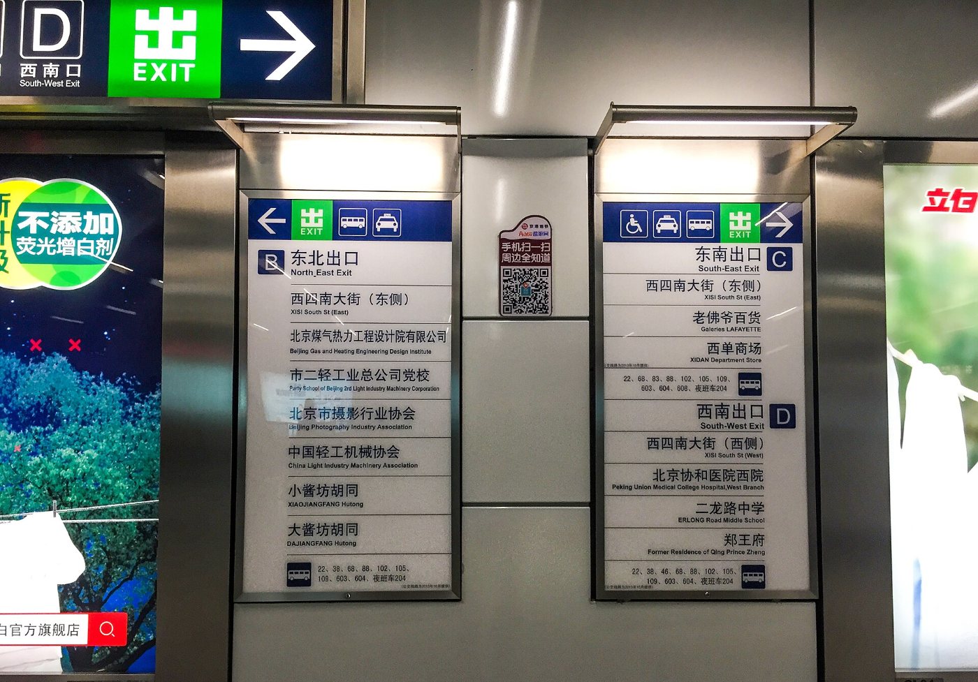 Signs in the Beijing metro with exit letters and a list of places at each exit, under an EXIT sign