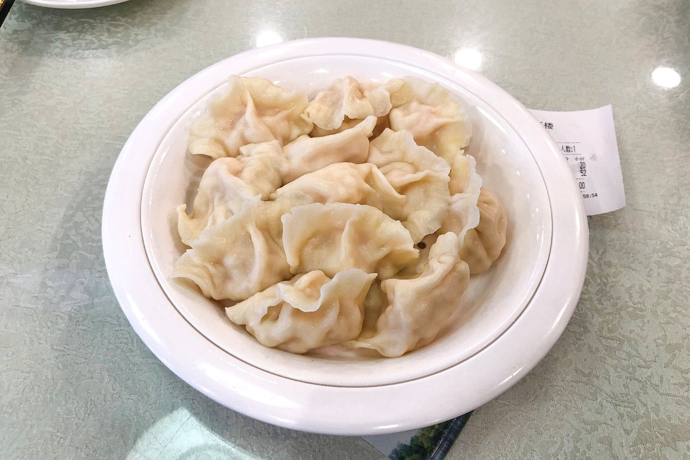 Talerz pierożków jiaozi z krewetkami na stole w pekińskiej restauracji