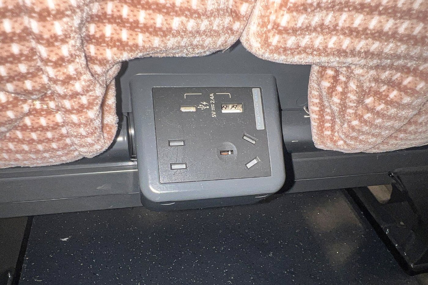 A socket under a seat on a Chinese bullet train: two flat type A slots, three angled type I slots and two USB ports