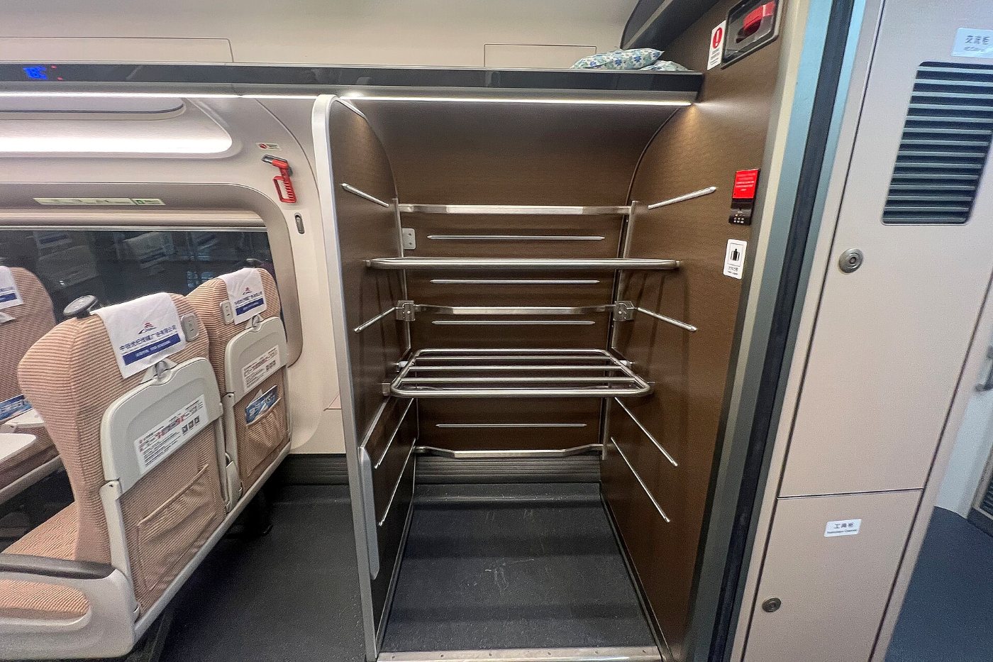 Racks for large suitcases at the end of a Chinese bullet train carriage, next to rows of seats