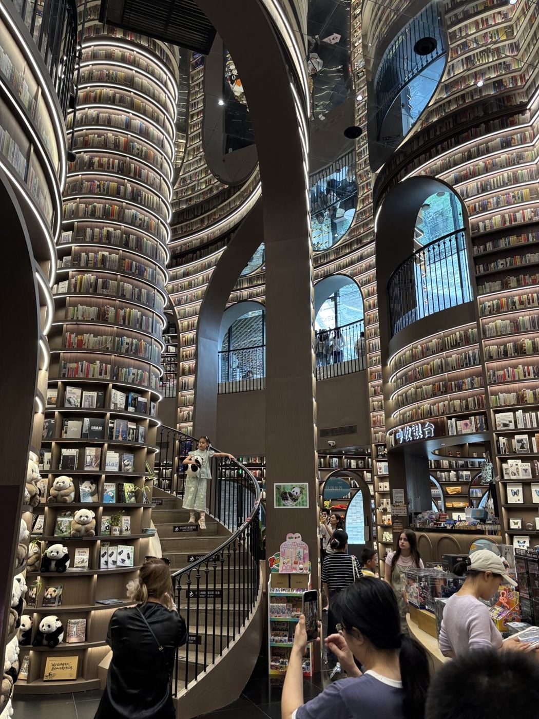 Inside the Zhongshuge bookshop in Dujiangyan: bookshelves rise to the ceiling, with winding stairs between them
